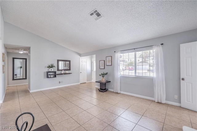 905 Smith St, Las Vegas, NV 89108 - unfurnished living room featuring vaulted ceiling, light tile patterned floors, and a textured ceiling
