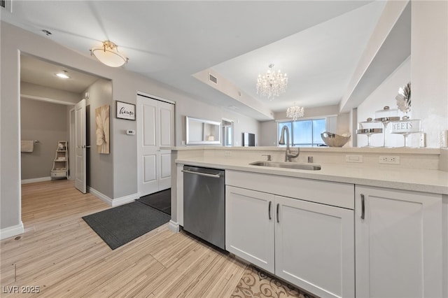 8255 Las Vegas Blvd Unit 809, Las Vegas, NV 89123 - kitchen with stainless steel dishwasher, a chandelier, light wood-type flooring, white cabinetry, and a peninsula