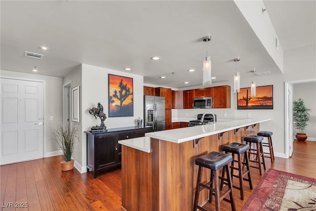 150 Las Vegas Blvd Unit 1906, Las Vegas, NV 89101 - kitchen with stainless steel appliances, a peninsula, a breakfast bar area, dark wood-style floors, and recessed lighting