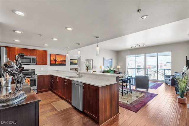150 Las Vegas Blvd Unit 1906, Las Vegas, NV 89101 - kitchen featuring stainless steel appliances, open floor plan, a peninsula, light countertops, and wood finished floors