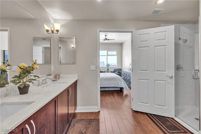 150 Las Vegas Blvd Unit 1906, Las Vegas, NV 89101 - full bathroom featuring connected bathroom, double vanity, wood finished floors, a shower stall, and ceiling fan