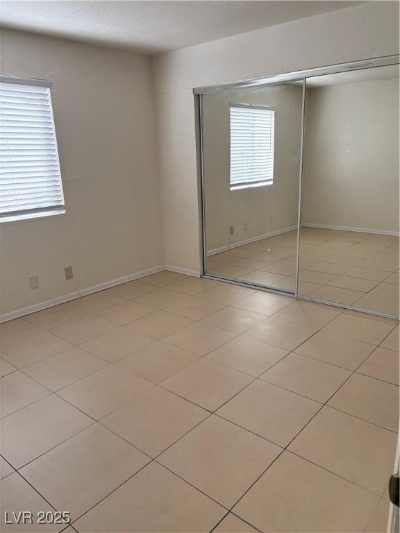 925 Falconhead Ln Unit 102, Las Vegas, NV 89128 - unfurnished bedroom featuring a closet and baseboards