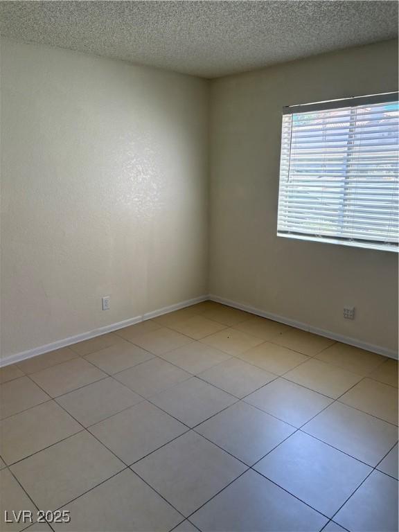 925 Falconhead Ln Unit 102, Las Vegas, NV 89128 - spare room featuring a textured ceiling and baseboards