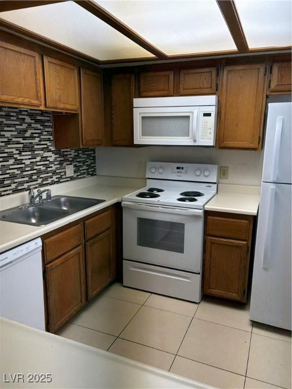 925 Falconhead Ln Unit 102, Las Vegas, NV 89128 - kitchen featuring white appliances, light tile patterned flooring, light countertops, and decorative backsplash