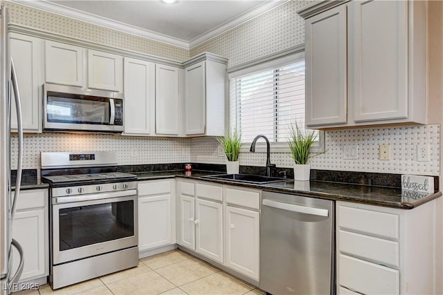 5516 Tantalum Ln, Las Vegas, NV 89122 - kitchen with stainless steel appliances, crown molding, light tile patterned floors, dark stone counters, and decorative backsplash