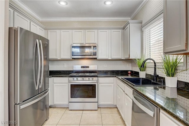 5516 Tantalum Ln, Las Vegas, NV 89122 - kitchen featuring appliances with stainless steel finishes, crown molding, light tile patterned flooring, dark stone countertops, and decorative backsplash