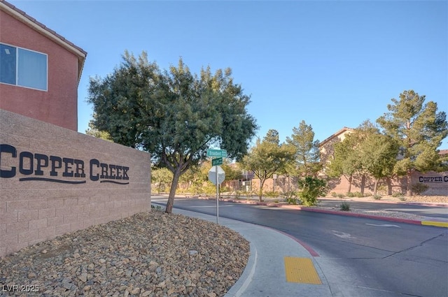 5516 Tantalum Ln, Las Vegas, NV 89122 - view of asphalt road with sidewalks, traffic signs, and curbs