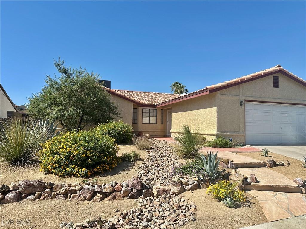 6357 Cobalt Ln, Las Vegas, NV 89146 - ranch-style house with stucco siding, an attached garage, a tiled roof, and concrete driveway