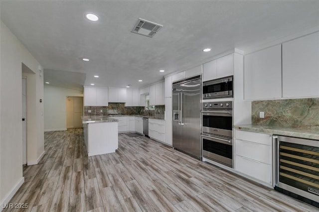 3708 Lorraine Ln, Las Vegas, NV 89120 - kitchen with built in appliances, wine cooler, recessed lighting, light wood finished floors, and decorative backsplash