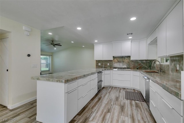 3708 Lorraine Ln, Las Vegas, NV 89120 - kitchen with a peninsula, light wood-style floors, backsplash, white cabinetry, and recessed lighting