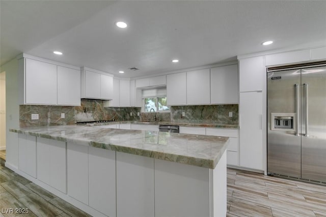3708 Lorraine Ln, Las Vegas, NV 89120 - kitchen with stainless steel appliances, a peninsula, white cabinetry, light wood-style floors, and recessed lighting