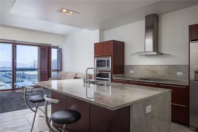 4471 Dean Martin Dr Unit 2406, Las Vegas, NV 89103 - kitchen with wall chimney exhaust hood, stainless steel appliances, modern cabinets, a kitchen breakfast bar, and a kitchen island with sink