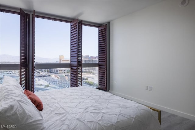 4471 Dean Martin Dr Unit 2406, Las Vegas, NV 89103 - bedroom featuring a wall of windows and wood finished floors