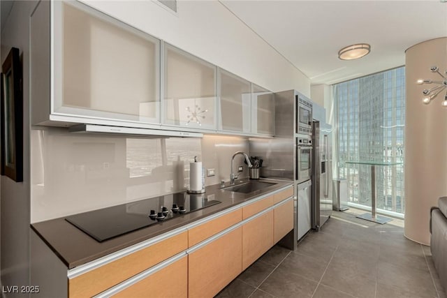 3722 Las Vegas Blvd Unit 3209, Las Vegas, NV 89158 - kitchen with a wall of windows, black electric cooktop, ventilation hood, tasteful backsplash, and dark tile patterned flooring