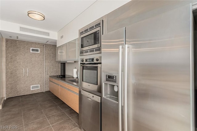 3722 Las Vegas Blvd Unit 3209, Las Vegas, NV 89158 - kitchen featuring stainless steel appliances, dark tile patterned flooring, and dark countertops