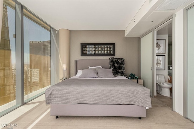 3722 Las Vegas Blvd Unit 3209, Las Vegas, NV 89158 - bedroom with light carpet, multiple windows, and connected bathroom