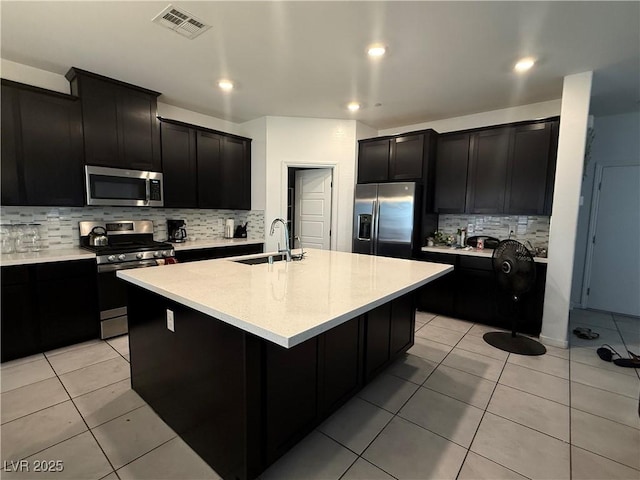 1618 Dakota Group Ave, North Las Vegas, NV 89084 - kitchen featuring stainless steel appliances, dark cabinets, tasteful backsplash, light countertops, and recessed lighting