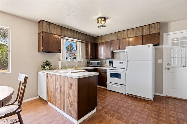 585 W Ingram Ave, Overton, NV 89040 - kitchen with white appliances, a peninsula, light countertops, and plenty of natural light