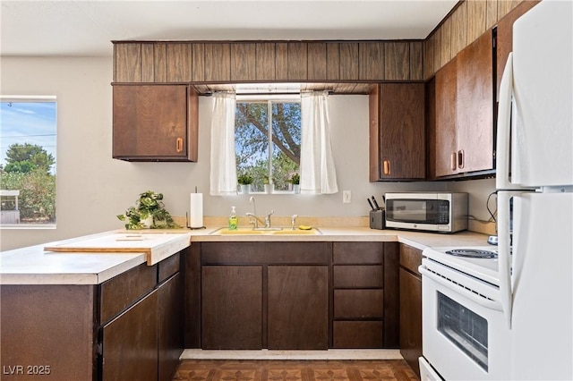 585 W Ingram Ave, Overton, NV 89040 - kitchen with white appliances, light countertops, dark brown cabinetry, and a peninsula