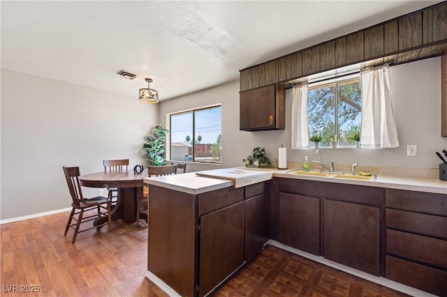 585 W Ingram Ave, Overton, NV 89040 - kitchen featuring light countertops, a peninsula, and dark brown cabinetry