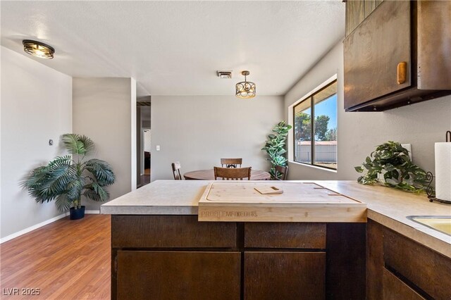 585 W Ingram Ave, Overton, NV 89040 - kitchen featuring dark brown cabinets, light wood-style flooring, light countertops, and a peninsula