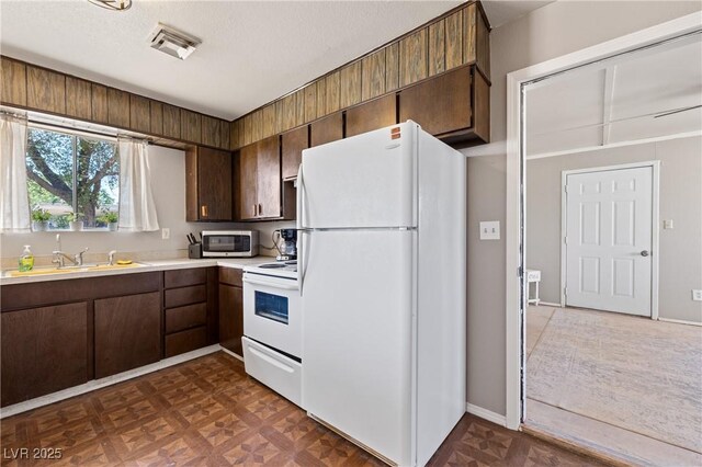 585 W Ingram Ave, Overton, NV 89040 - kitchen with white appliances, light countertops, and dark brown cabinets