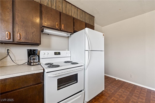585 W Ingram Ave, Overton, NV 89040 - kitchen featuring white appliances, dark brown cabinets, under cabinet range hood, and light countertops