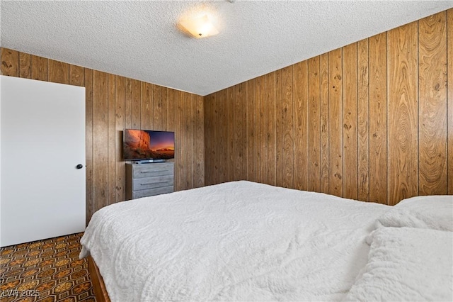 585 W Ingram Ave, Overton, NV 89040 - bedroom with wooden walls, a textured ceiling, and dark carpet