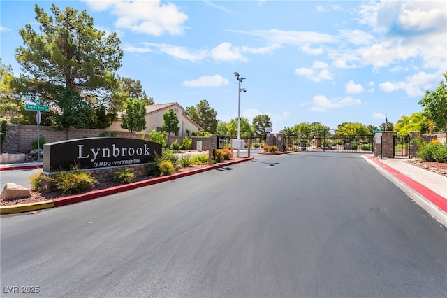 4837 River Splash Ave, Las Vegas, NV 89131 - view of asphalt road featuring street lights, curbs, a gate, a gated entry, and sidewalks