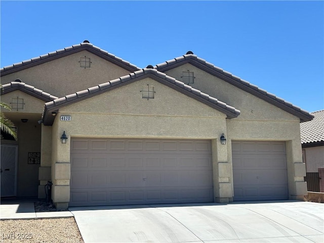 4620 Ventana Rey St, North Las Vegas, NV 89081 - view of front facade featuring an attached garage, a tiled roof, stucco siding, and concrete driveway