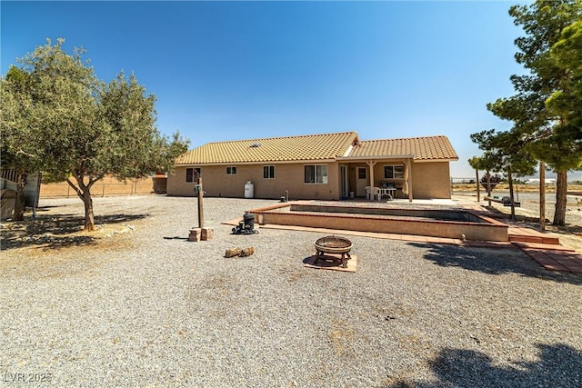 2730 Banyon St, Pahrump, NV 89048 - back of house featuring an outdoor fire pit, a tiled roof, and stucco siding