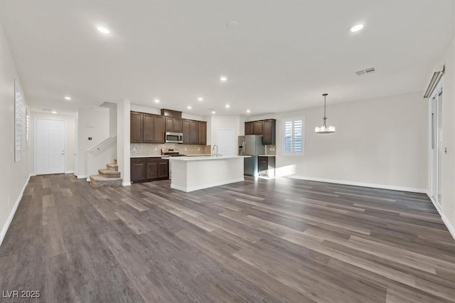 9327 Ettrick Ct, Las Vegas, NV 89178 - unfurnished living room with dark wood-style flooring, recessed lighting, a chandelier, and stairway