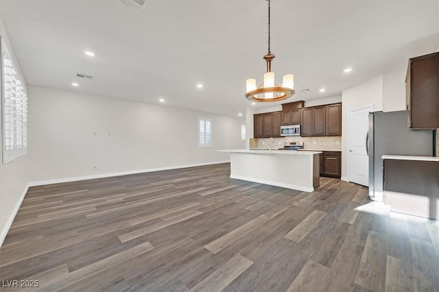 9327 Ettrick Ct, Las Vegas, NV 89178 - kitchen featuring stainless steel appliances, open floor plan, backsplash, a chandelier, and a kitchen island