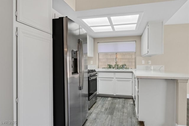 808 Vermillion Dr, Henderson, NV 89002 - kitchen featuring appliances with stainless steel finishes, light wood-type flooring, backsplash, white cabinets, and light countertops
