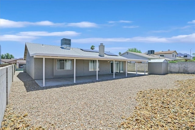 808 Vermillion Dr, Henderson, NV 89002 - rear view of house with a patio area, roof mounted solar panels, a storage shed, and a fenced backyard