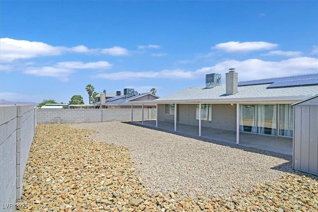 808 Vermillion Dr, Henderson, NV 89002 - back of property with a patio, a fenced backyard, a chimney, and roof mounted solar panels