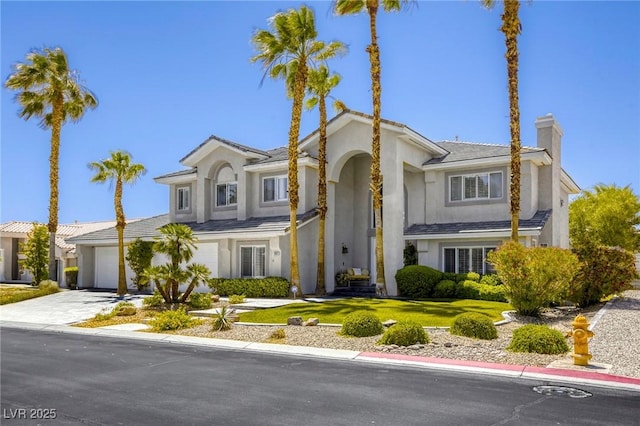 9905 Fox Springs Dr, Las Vegas, NV 89117 - view of front of house with driveway, a chimney, stucco siding, and a front lawn