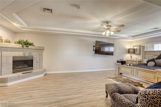 9905 Fox Springs Dr, Las Vegas, NV 89117 - bedroom featuring a raised ceiling, wood finished floors, a premium fireplace, and a ceiling fan