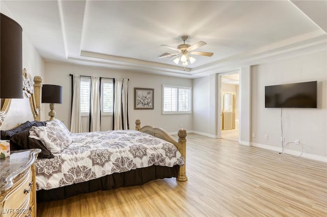 9905 Fox Springs Dr, Las Vegas, NV 89117 - bedroom with a tray ceiling, multiple windows, and light wood-type flooring