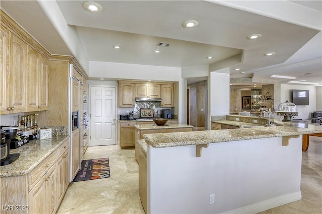 9905 Fox Springs Dr, Las Vegas, NV 89117 - kitchen featuring a kitchen breakfast bar, under cabinet range hood, light brown cabinetry, recessed lighting, and a large island