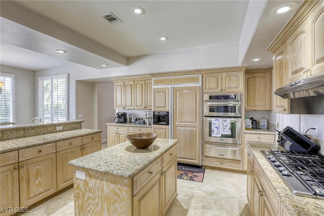 9905 Fox Springs Dr, Las Vegas, NV 89117 - kitchen with light brown cabinets, a warming drawer, stainless steel appliances, light stone countertops, and recessed lighting