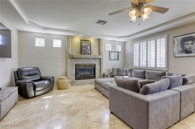 9905 Fox Springs Dr, Las Vegas, NV 89117 - living area featuring a tray ceiling, a ceiling fan, a tile fireplace, and light marble finish floors