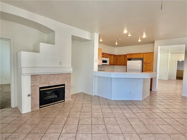 338 Brilliant Summit Cir, Henderson, NV 89052 - kitchen featuring white appliances, light tile patterned flooring, light countertops, recessed lighting, and a peninsula
