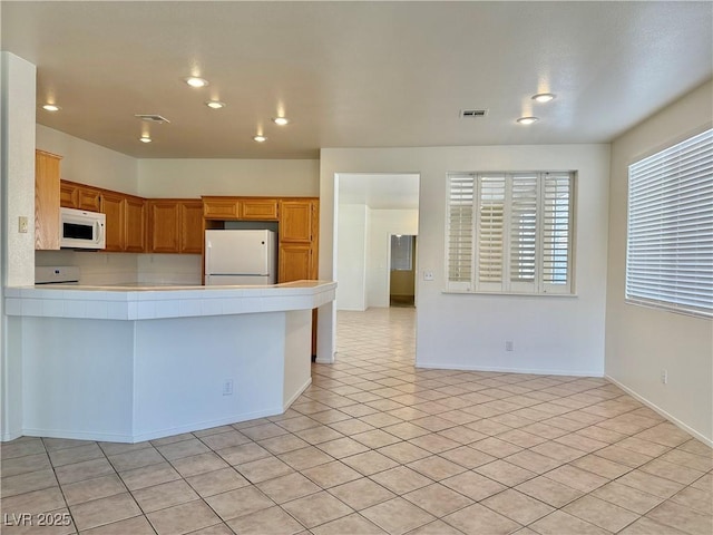338 Brilliant Summit Cir, Henderson, NV 89052 - kitchen featuring white appliances, tile countertops, recessed lighting, a peninsula, and light tile patterned flooring