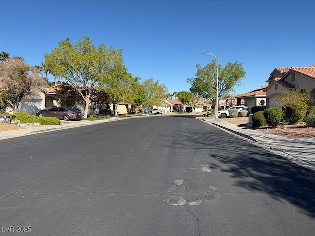 338 Brilliant Summit Cir, Henderson, NV 89052 - view of asphalt road featuring a residential view, street lighting, sidewalks, and curbs