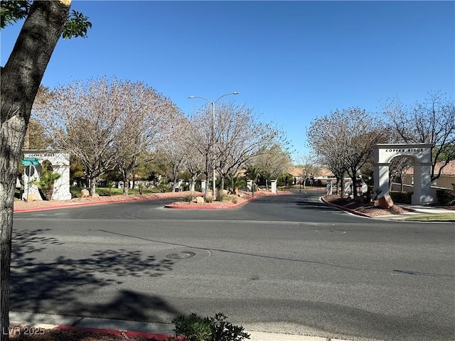 338 Brilliant Summit Cir, Henderson, NV 89052 - view of asphalt road featuring street lighting, curbs, and sidewalks