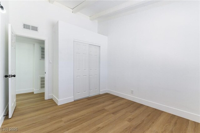 1916 Howard Ave, Las Vegas, NV 89104 - unfurnished bedroom featuring light wood-style flooring, beamed ceiling, a closet, and a high ceiling