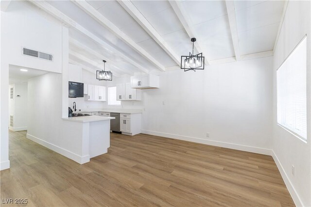 1916 Howard Ave, Las Vegas, NV 89104 - kitchen with a chandelier, stainless steel dishwasher, white cabinetry, a peninsula, and beamed ceiling