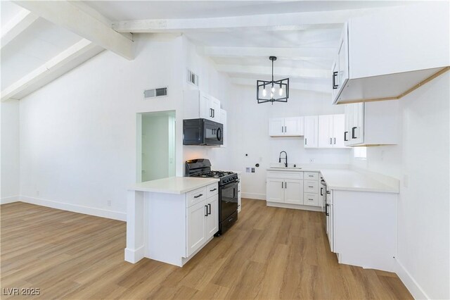 1916 Howard Ave, Las Vegas, NV 89104 - kitchen with black appliances, light wood-type flooring, a chandelier, beam ceiling, and light countertops