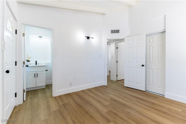 1916 Howard Ave, Las Vegas, NV 89104 - unfurnished bedroom featuring light wood-style floors, beam ceiling, connected bathroom, and a closet